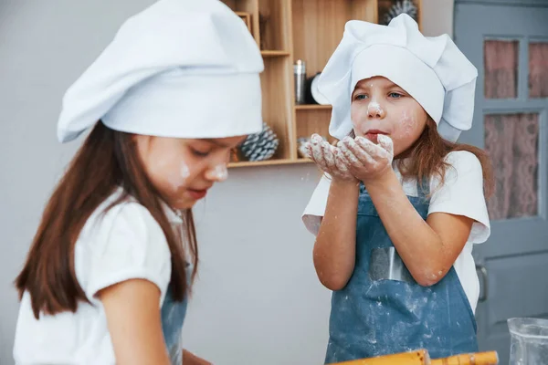 Δύο Μικρά Κορίτσια Μπλε Στολή Σεφ Διασκεδάζουν Και Ετοιμάζουν Φαγητό — Φωτογραφία Αρχείου