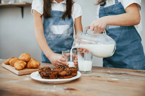 Närbild Två Små Flickor Blå Kock Uniform Som Häller Mjölk — Stockfoto