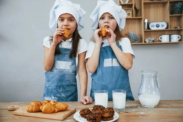 Två Små Flickor Blå Kock Uniform Äta Mat Köket — Stockfoto