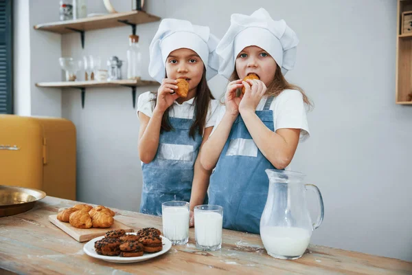 Två Små Flickor Blå Kock Uniform Äta Mat Köket — Stockfoto