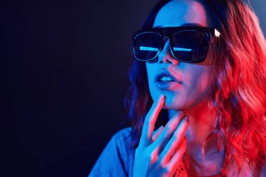 Stüdyoda mavi ve kırmızı gözlüklü genç bir kızın portresi..