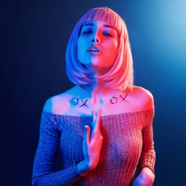 Stüdyoda sarı saçlı, kırmızı ve mavi neonlu genç kız portresi..