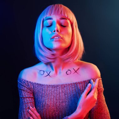 Stüdyoda sarı saçlı, kırmızı ve mavi neonlu genç kız portresi..