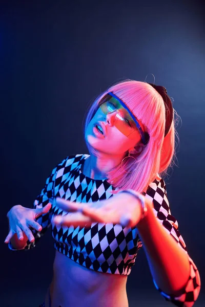 Stüdyoda kırmızı ve mavi gözlüklü sarı saçlı genç kızın portresi..