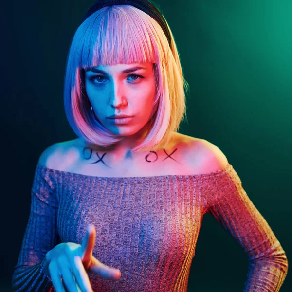 Stüdyoda sarı saçlı, kırmızı ve mavi neonlu genç kız portresi..