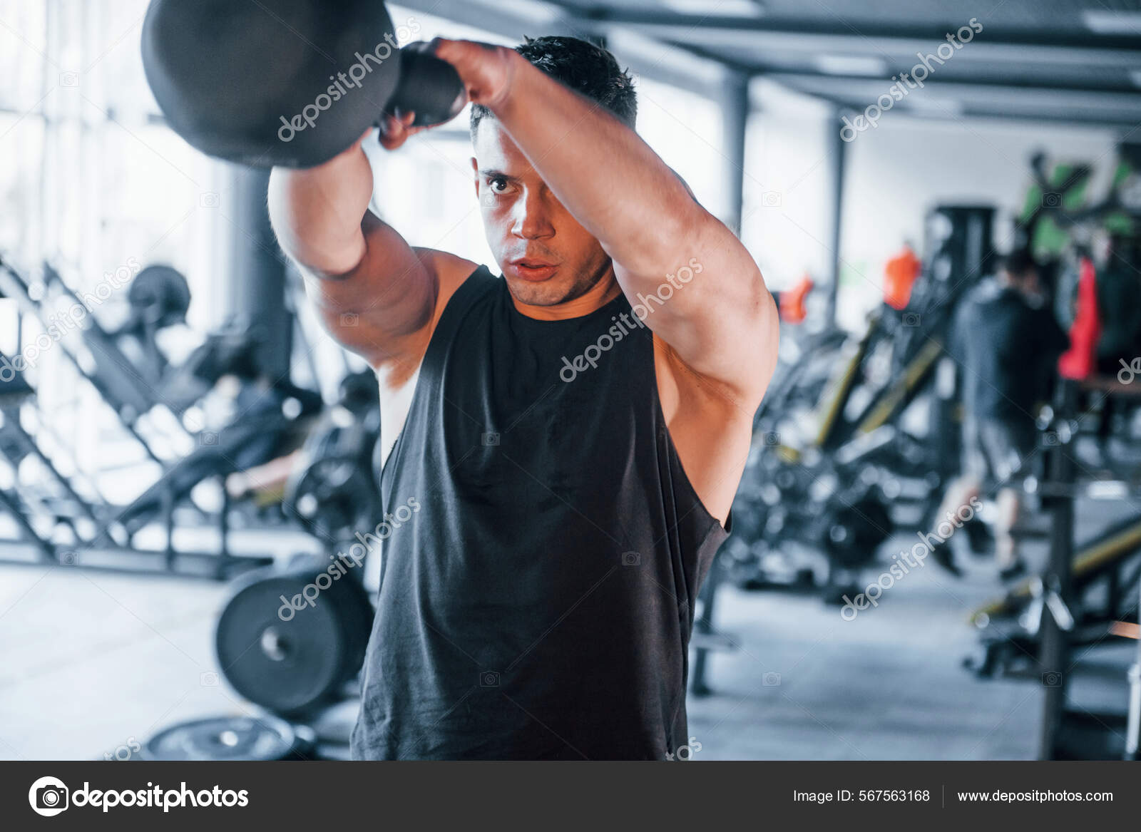 Strong young man in sportive clothes doing exercises with heavy weights in  the gym 15255362 Stock Photo at Vecteezy