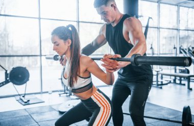 Spor salonunda ağır toplarla egzersiz yapan genç sporcular..