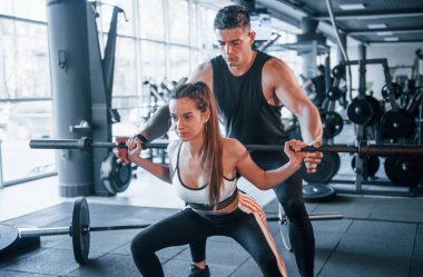 Spor salonunda ağır toplarla egzersiz yapan genç sporcular..