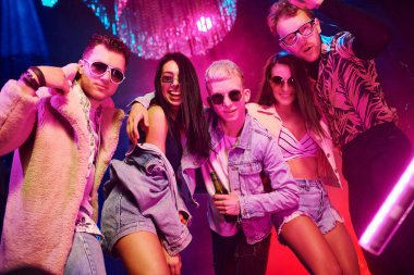 Kameraya poz veriyorum. Gençler gece kulübünde renkli lazer ışıklarıyla eğleniyorlar..