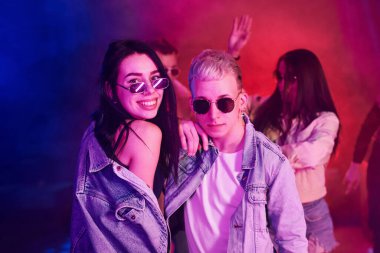 Gençler gece kulübünde renkli lazer ışıklarıyla eğleniyorlar..