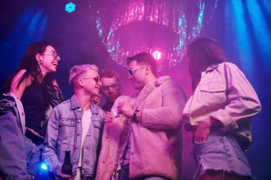 Uyuşturucu almak. Gençler gece kulübünde renkli lazer ışıklarıyla eğleniyorlar..