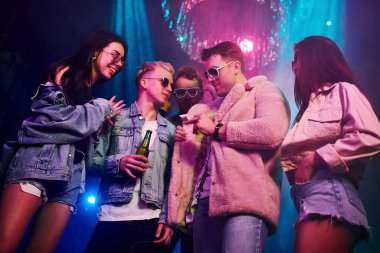 Uyuşturucu almak. Gençler gece kulübünde renkli lazer ışıklarıyla eğleniyorlar..