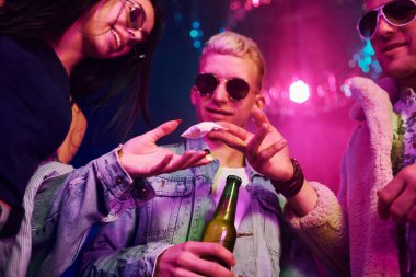 Uyuşturucu almak. Gençler gece kulübünde renkli lazer ışıklarıyla eğleniyorlar..