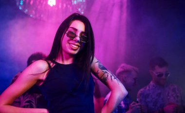 Gençler gece kulübünde renkli lazer ışıklarıyla eğleniyorlar..