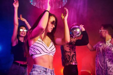 Gençler gece kulübünde renkli lazer ışıklarıyla eğleniyorlar..