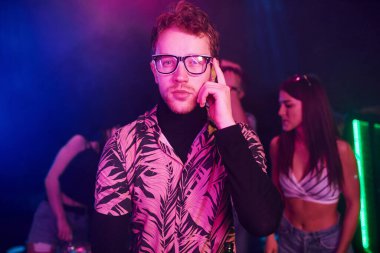 Gençler gece kulübünde renkli lazer ışıklarıyla eğleniyorlar..