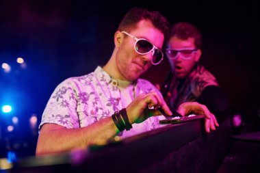 Şık elbiseli ve güneş gözlüklü genç adam gece kulübünde uyuşturucu kokluyor..