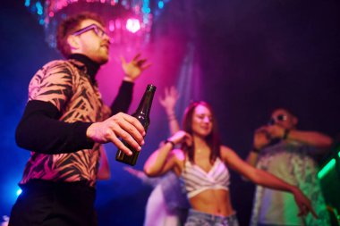 Alkollü parti. Gençler gece kulübünde renkli lazer ışıklarıyla eğleniyorlar..