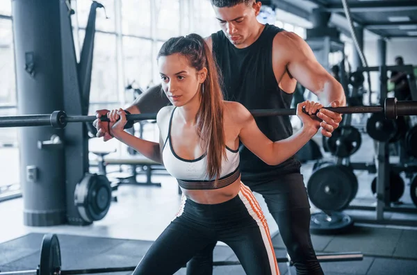 Spor salonunda ağır toplarla egzersiz yapan genç sporcular..