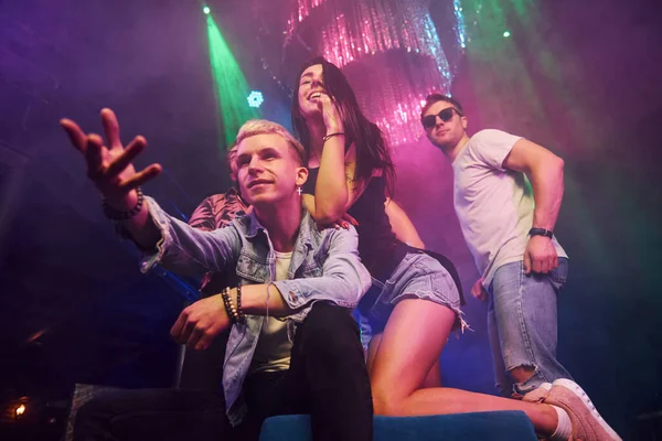 Gençler gece kulübünde renkli lazer ışıklarıyla eğleniyorlar..