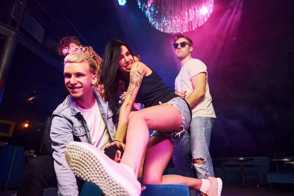 Gençler gece kulübünde renkli lazer ışıklarıyla eğleniyorlar..