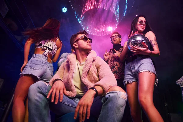 Kameraya poz veriyorum. Gençler gece kulübünde renkli lazer ışıklarıyla eğleniyorlar..