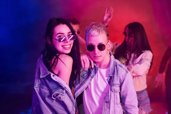 Gençler gece kulübünde renkli lazer ışıklarıyla eğleniyorlar..