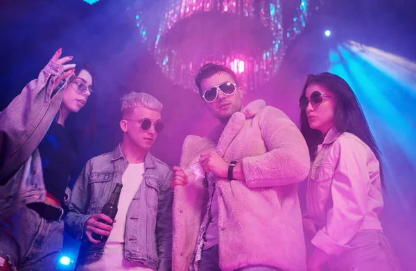 Uyuşturucu almak. Gençler gece kulübünde renkli lazer ışıklarıyla eğleniyorlar..