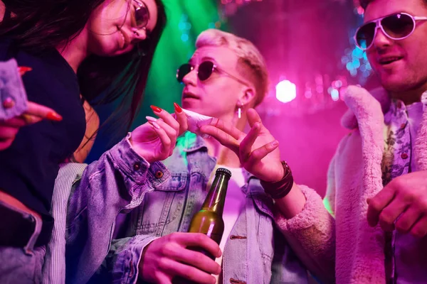 Uyuşturucu almak. Gençler gece kulübünde renkli lazer ışıklarıyla eğleniyorlar..