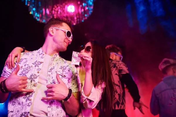 Uyuşturucu almak. Gençler gece kulübünde renkli lazer ışıklarıyla eğleniyorlar..