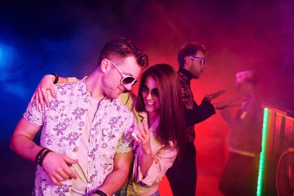 Uyuşturucu almak. Gençler gece kulübünde renkli lazer ışıklarıyla eğleniyorlar..