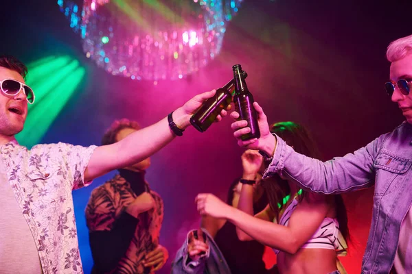 술병을 축하하고 두드리는 청소년들은 레이저 조명을 가지고 나이트 클럽에서 즐거운 — 스톡 사진
