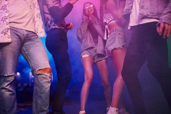 Gençler gece kulübünde renkli lazer ışıklarıyla eğleniyorlar..