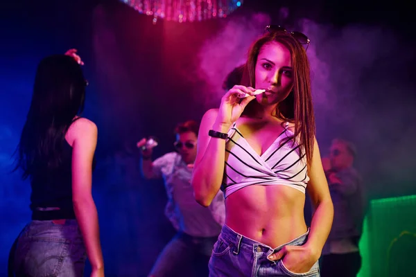 Gençler gece kulübünde renkli lazer ışıklarıyla eğleniyorlar..