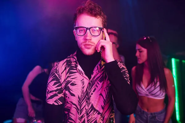 Gençler gece kulübünde renkli lazer ışıklarıyla eğleniyorlar..