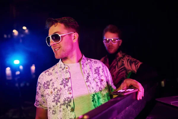 Şık elbiseli ve güneş gözlüklü genç adam gece kulübünde uyuşturucu kokluyor..