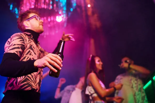 Alkollü parti. Gençler gece kulübünde renkli lazer ışıklarıyla eğleniyorlar..