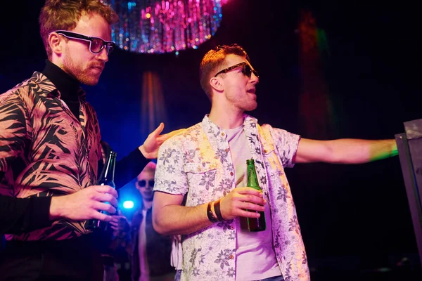 Gençler gece kulübünde renkli lazer ışıklarıyla eğleniyorlar..