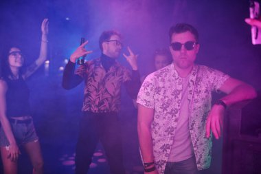 Gençler gece kulübünde renkli lazer ışıklarıyla eğleniyorlar..