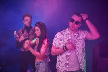 Gençler gece kulübünde renkli lazer ışıklarıyla eğleniyorlar..