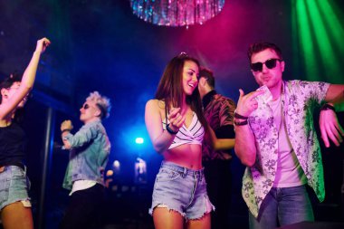 Gençler gece kulübünde renkli lazer ışıklarıyla eğleniyorlar..