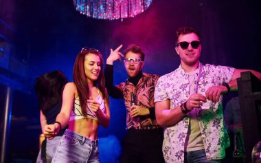 Gençler gece kulübünde renkli lazer ışıklarıyla eğleniyorlar..