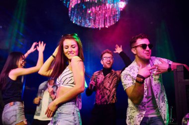 Gençler gece kulübünde renkli lazer ışıklarıyla eğleniyorlar..