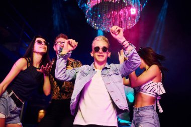 Gençler gece kulübünde renkli lazer ışıklarıyla eğleniyorlar..