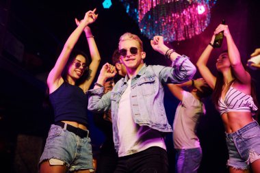 Gençler gece kulübünde renkli lazer ışıklarıyla eğleniyorlar..