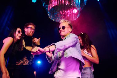 Gençler gece kulübünde renkli lazer ışıklarıyla eğleniyorlar..