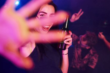 Odaklanmamış el. Gençler gece kulübünde renkli lazer ışıklarıyla eğleniyorlar..