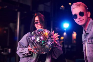 Gençler gece kulübünde renkli lazer ışıklarıyla eğleniyorlar..