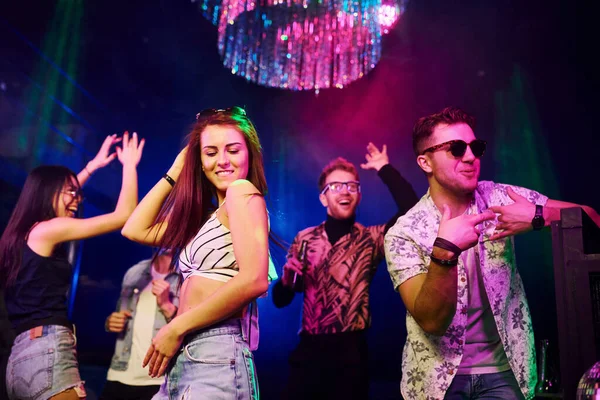 Gençler gece kulübünde renkli lazer ışıklarıyla eğleniyorlar..