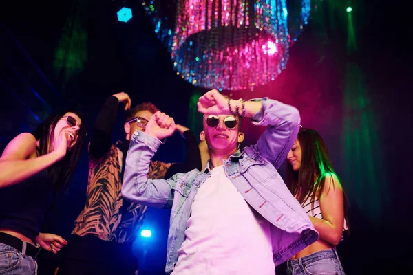 Gençler gece kulübünde renkli lazer ışıklarıyla eğleniyorlar..